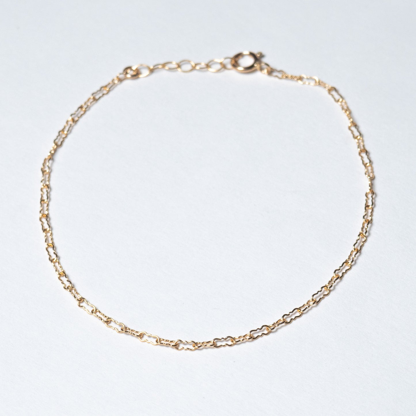 Dainty gold filled Crinkle chain bracelet on white background. 
