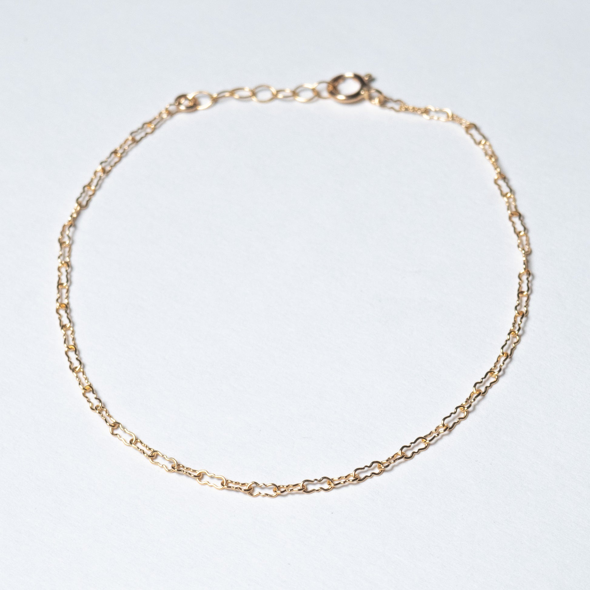 Dainty gold filled Crinkle chain bracelet on white background. 